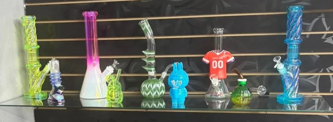 A shelf of colored glassware against the black slatwall